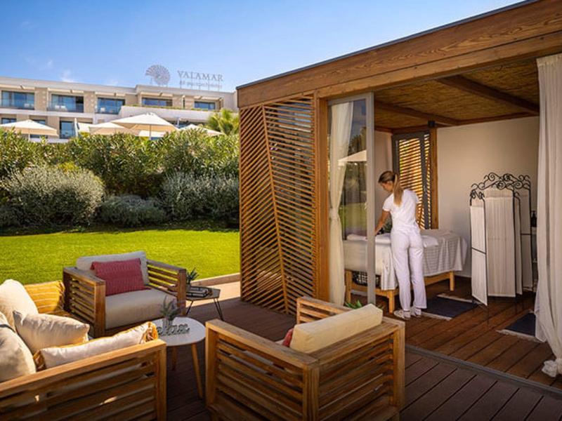Área de jardín moderna con salón de madera y una persona en el vestidor abierto de un hotel.