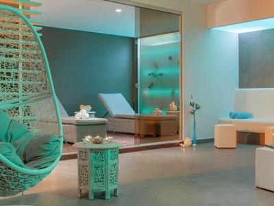 Salon moderne avec chaise suspendue verte et décoration minimaliste.