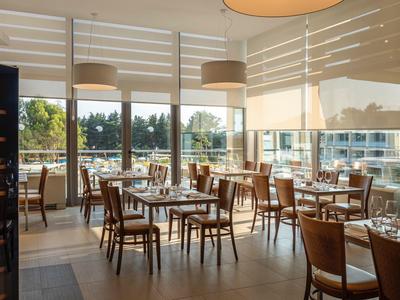 Restaurant lumineux avec mobilier en bois et grande fenêtre donnant sur l'extérieur en plein jour