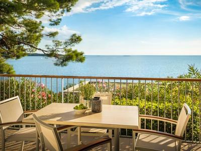 Terrace with chairs and table overlooking the sea and blue sky.