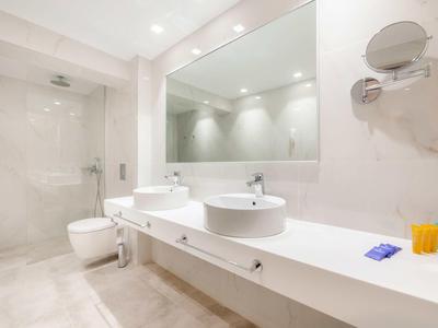 Modernes Badezimmer mit Doppelwaschbecken, großer Spiegel und Dusche mit Glaswand.