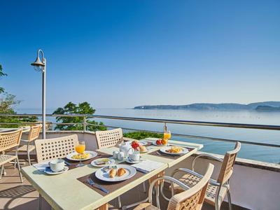Terrace with set table and sea view under clear sky