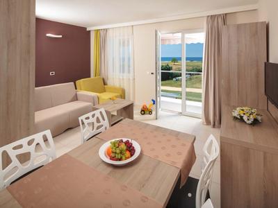 Soggiorno moderno con tavolo da pranzo, divani e vista sul mare e giardino