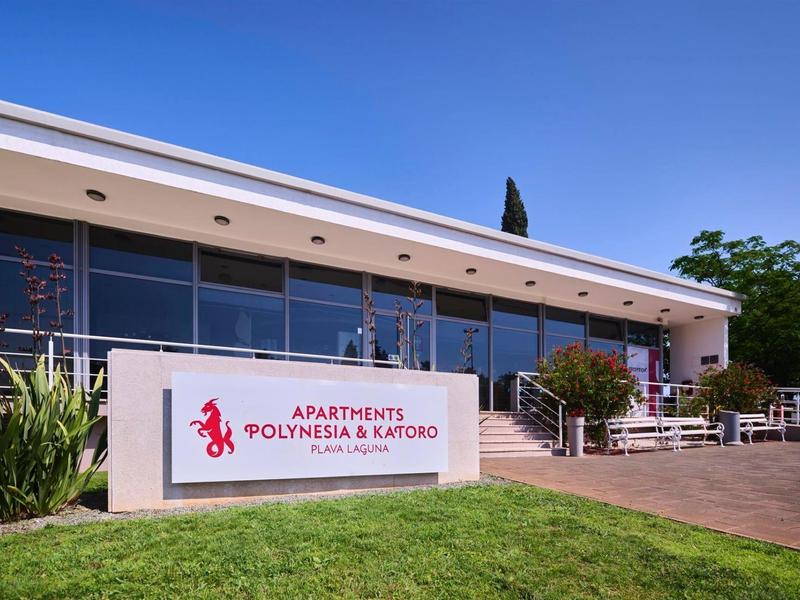 Edificio di appartamenti moderno con terrazza e piante sotto un cielo limpido