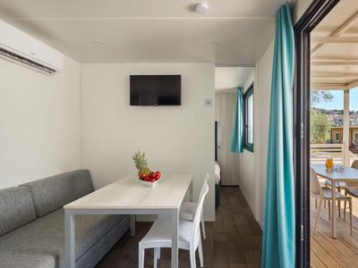 Moderner Essbereich mit Sitzbank, Stühlen und Blick auf Terrasse in Hotelzimmer