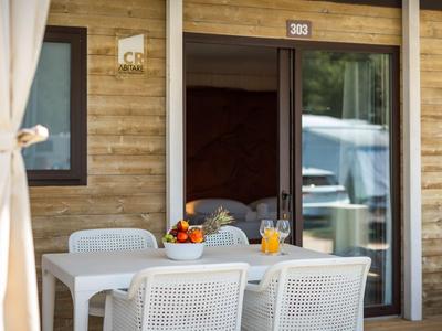 Moderner Sitzbereich mit weißem Tisch und Stühlen vor einer Holztür im Hotel.
