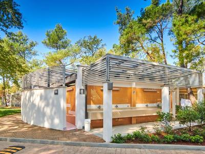 Nowoczesna zewnętrzna toaleta publiczna z drzewami w tle