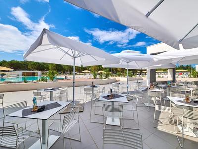 Pusta terasa z stołami, krzesłami i parasolami podczas słonecznego dnia