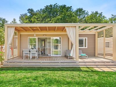 Nowoczesny bungalow z otwartą werandą i ogrodem, idealny na wakacyjny pobyt.