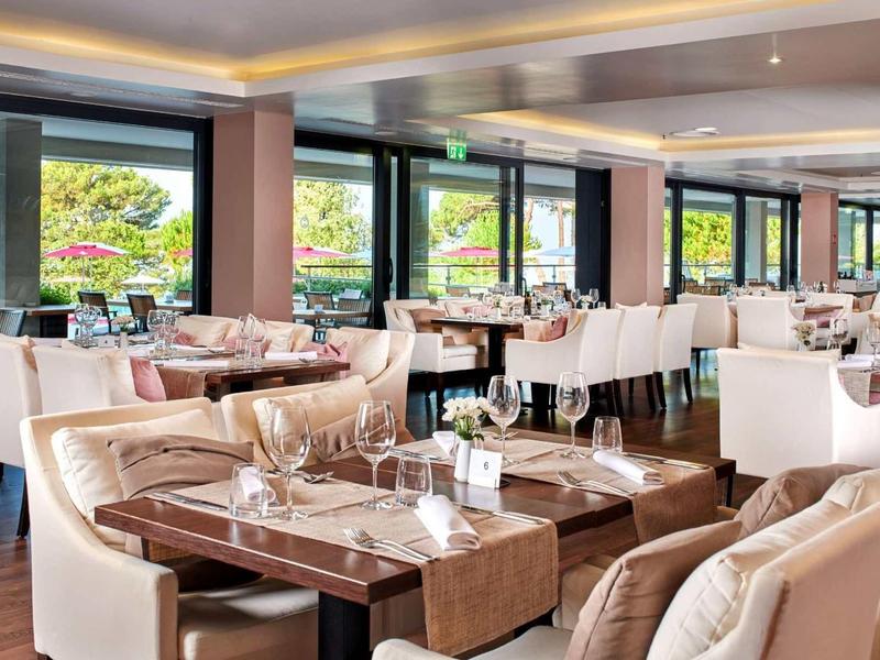 Jasna jadalnia z wygodnymi krzesłami i dużymi oknami z widokiem na zieleń.