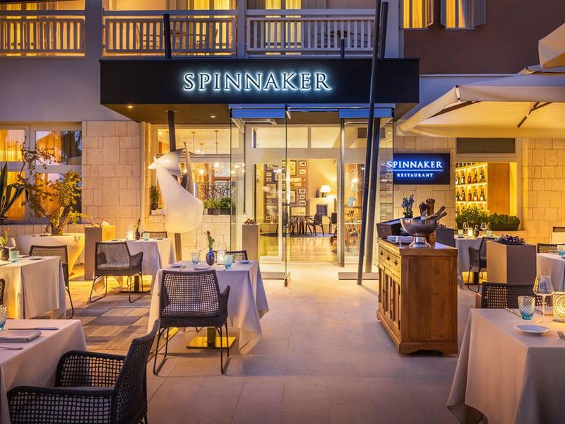 Elegantní venkovní restaurace s prostřenými stoly a posezením v noci.