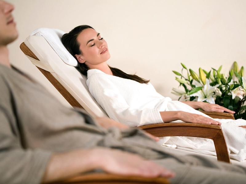 Un couple se détend sur des chaises longues dans un spa ou un espace bien-être.