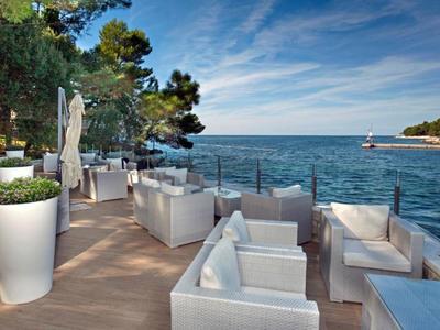 Terrasse avec mobilier lounge blanc et vue sur la mer par une journée ensoleillée