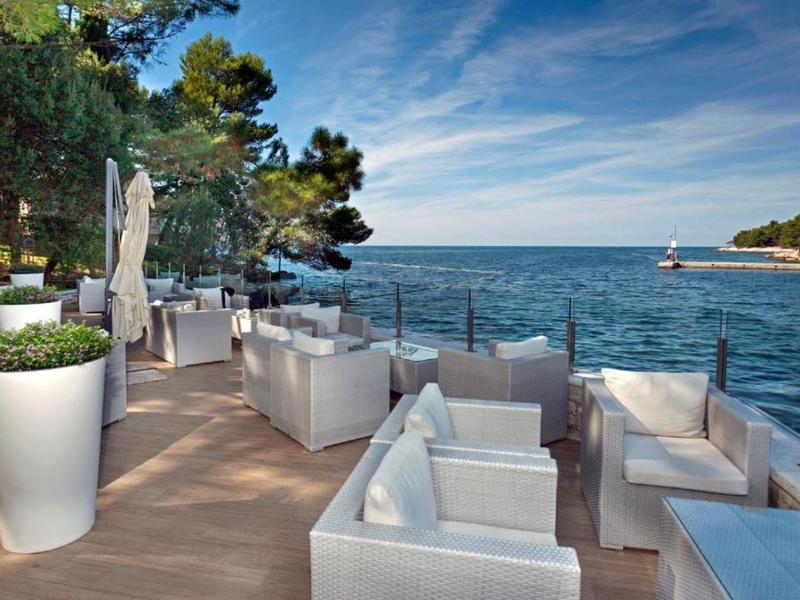 Terrasse avec mobilier lounge blanc et vue sur la mer par une journée ensoleillée
