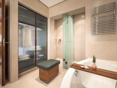 Modernes Badezimmer mit Glasdusche, Badewanne, beheiztem Handtuchhalter und großem Schrank mit Schiebetüren.