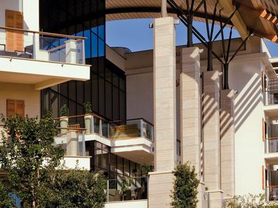 Moderner Hotelkomplex mit Balkonen, Glasfronten und ausladendem Dach bei Tageslicht.