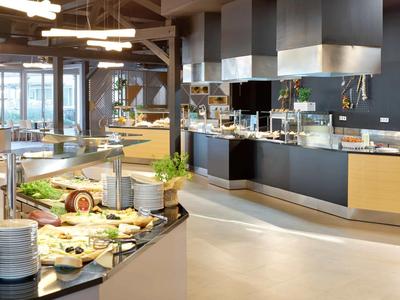 Nowoczesny bufet hotelowy z różnorodnością świeżych potraw i nowoczesnym oświetleniem.