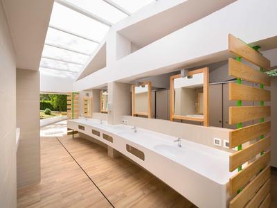 Bagno moderno e luminoso con grandi specchi e dettagli in legno.