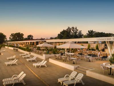 Hotel sulla spiaggia con lettini e aree coperte al tramonto