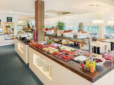 Buffet en un restaurante moderno con diferentes platos sobre una barra.