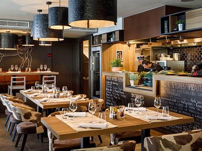 Restaurante acogedor con decoración de madera y mesas preparadas con luz cálida.