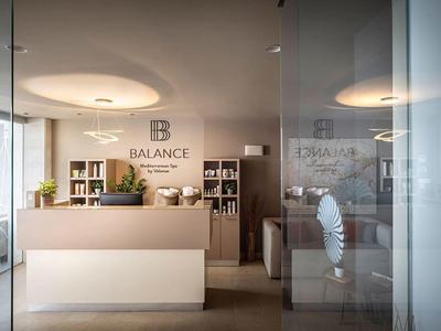 Moderne hotelreceptie met balie en planten.