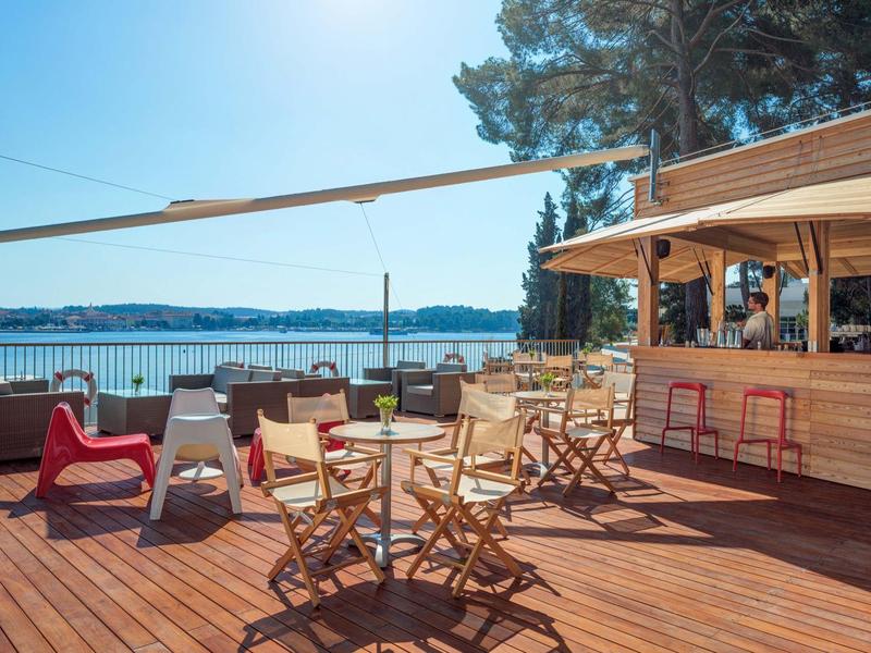 Terras met houten dek, zitplaatsen en bar met uitzicht op de zee