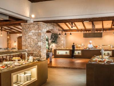 Amplio salón de desayuno con bufé y ambiente cálido en un hotel.