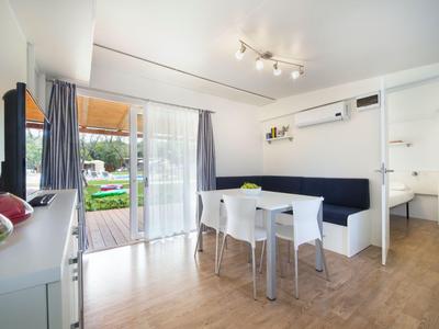 Moderner Essbereich mit weißem Tisch, Stühlen und direktem Zugang zur Terrasse.