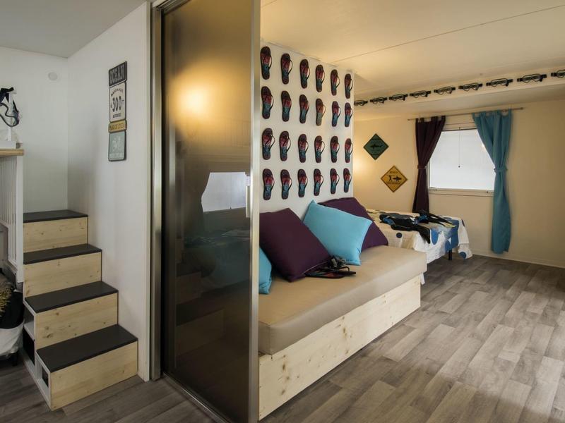 Habitación de hotel moderna con escalera de madera, cómoda área de descanso y decoración de pared elegante.