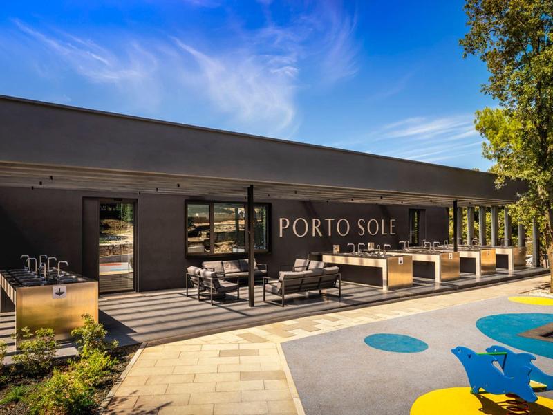 Modern hotel with terrace and outdoor furniture under blue sky