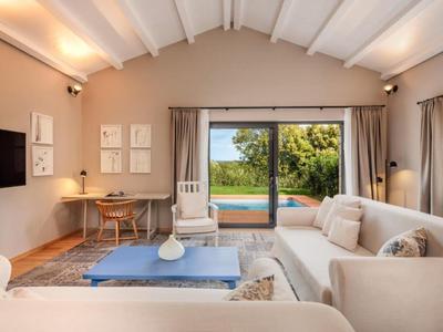 Przytulny salon z sofami, biurkiem i widokiem na basen na zewnątrz.