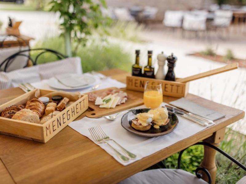 Stół na zewnątrz z różnymi rodzajami chleba, serem i masłem na śniadanie.