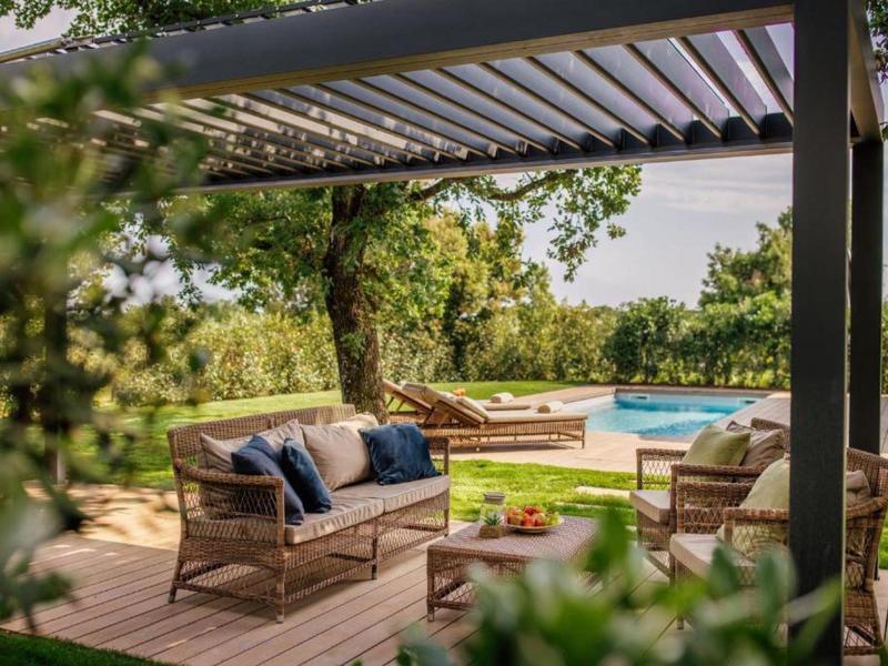 Przytulny taras z miejscem do siedzenia i widokiem na basen w zielonym ogrodzie