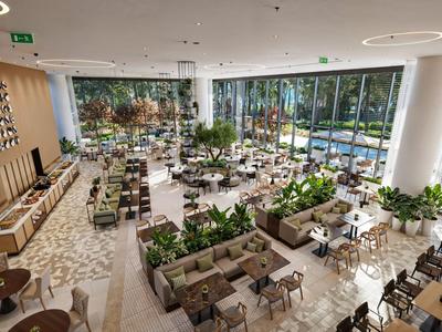 Prostorná moderní jídelna s mnoha stoly a rostlinami v světlé místnosti s velkými okny.