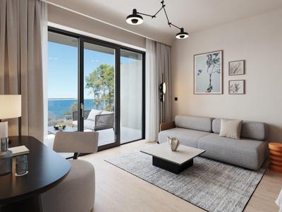 Modern living room with sofa and sea view through large windows.