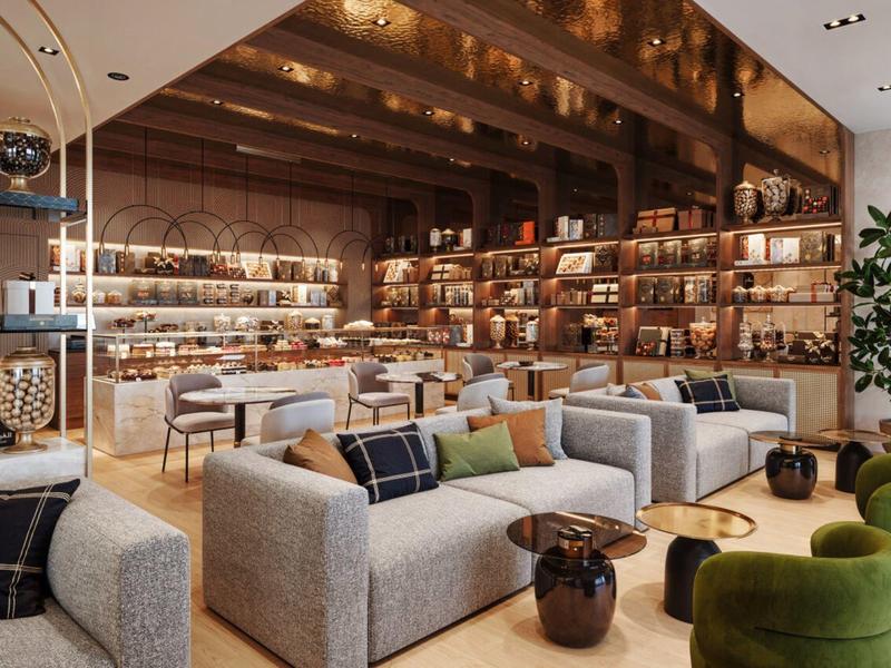 Eleganter Hotel-Loungebereich mit grauen Sofas, grünen Sesseln und beleuchtetem Barbereich.