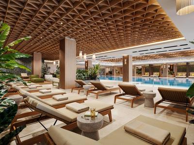Nowoczesna strefa wellness z basenem, leżakami i zielonymi roślinami w ciepłym świetle.