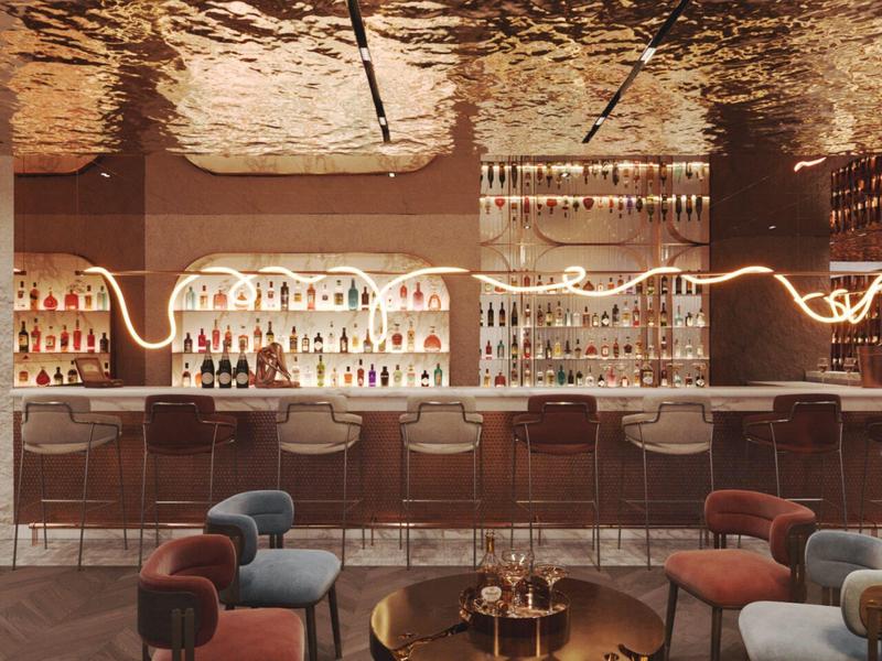 Nowoczesny bar hotelowy z oświetlonymi półkami, stołkami barowymi i wygodnymi fotelami w ciepłym świetle.