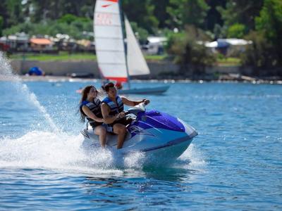 Due persone che guidano un jet ski su un corso d'acqua con bel tempo.