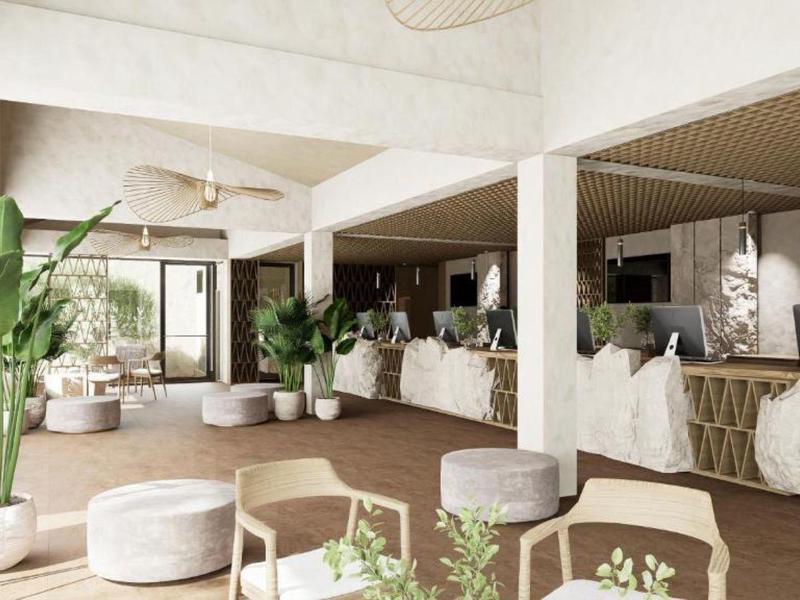 Jasna przestrzeń w holu hotelowym z nowoczesnymi meblami i zielonymi roślinami.