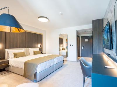 Modernes Hotelzimmer mit großem Bett, indirekter Beleuchtung und stilvollem Design.