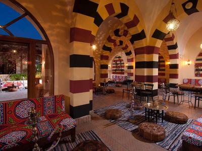 Accogliente ristorante colorato con cuscini e spettacolari archi a strisce.