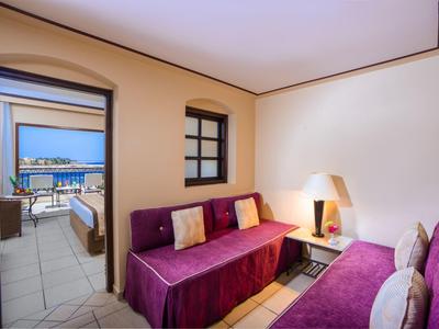 Soggiorno con divani viola che si affacciano su una terrazza con vista sul mare.