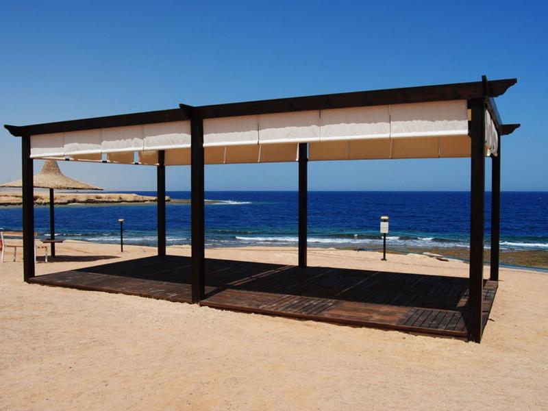 Pabellón abierto con techo de lona en la playa con vistas al mar azul