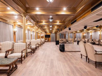 Grote elegante eetzaal met houten plafond en comfortabele zitplaatsen.