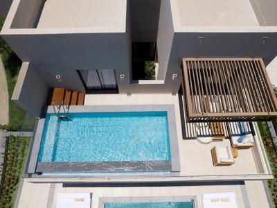 Modernes Haus mit rechteckigem Pool, Terrasse, Holzgitter und Gartenbereich aus Vogelperspektive.