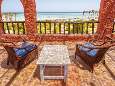 Terrazza con poltrone in vimini e vista sul mare.