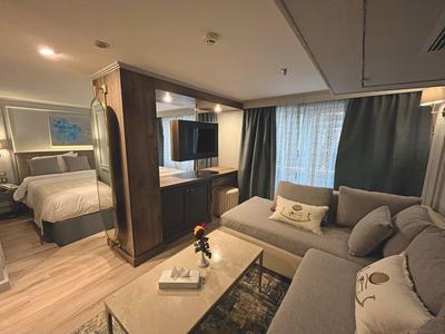 Habitación de hotel moderna con cama cómoda, zona de estar y ventana grande.