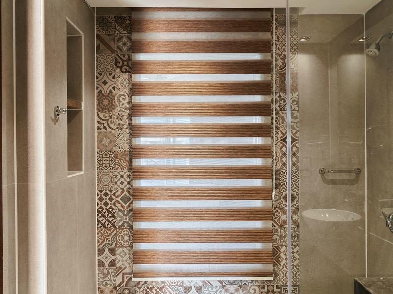 Modern shower area with patterned tiles and striped shower screen in neutral tones.